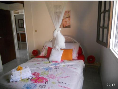 une chambre avec un grand lit à baldaquin dans l'établissement Chez Tatie Juju, à Sainte-Anne
