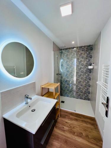 une salle de bain avec un lavabo et une douche dans l'établissement Maison proche océan - parking - wifi - clim, à La Tremblade