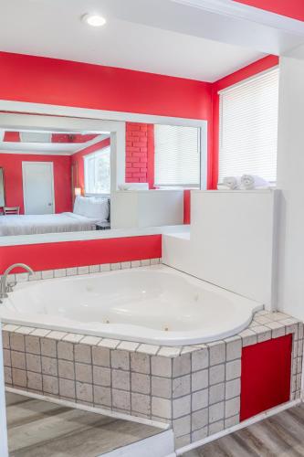 a large white tub in a room with red walls at Atlantis Inn - Tybee Island in Tybee Island