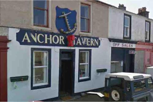 a sign for a kitchen tavern on the side of a building at Fraoch, Pets welcome in Port Bannatyne