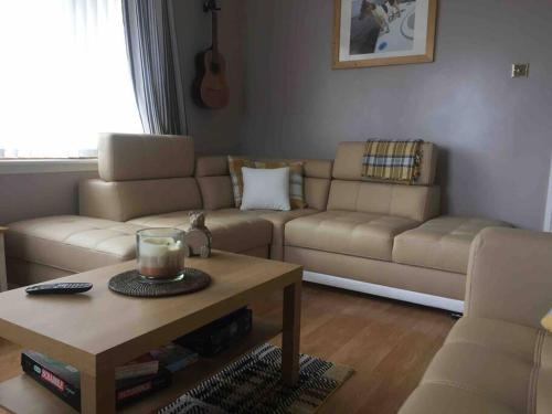 a living room with a couch and a coffee table at Fraoch, Pets welcome in Port Bannatyne