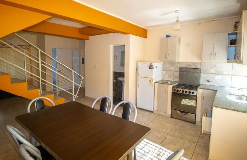 una cucina con tavolo e una cucina con elettrodomestici bianchi di Duplex Girasoles zona Termal a Monte Caseros