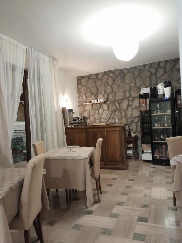 a dining room with a table and a stone wall at Hotel Regina Yeti Bistrot in Sestola
