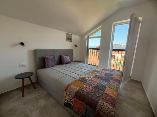 Un dormitorio con una cama y una ventana grande. en Vas Dom, en Soko Banja