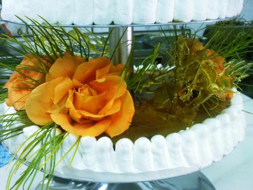 a white cake with orange flowers on top of it at Casa de los Bates in Motril
