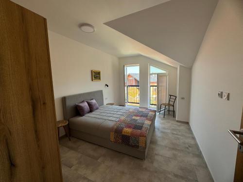 Un dormitorio con una cama y una ventana grande. en Vas Dom, en Soko Banja