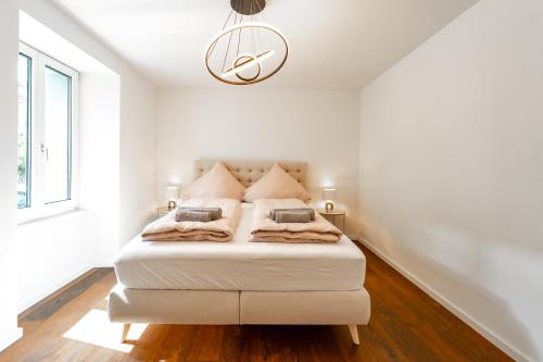 a white bedroom with a bed in a room at Modische Wohnung in der Nähe des Bahnhofs! in Winterthur