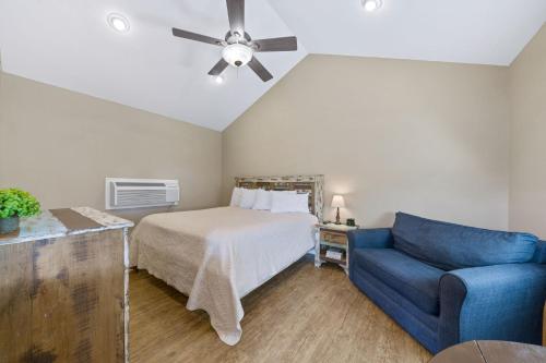 a bedroom with a bed and a blue couch at Blanco Riverside Cottages in Blanco