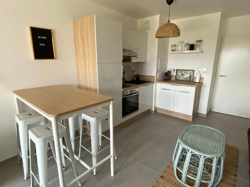 une cuisine avec une table et des tabourets dans une pièce dans l'établissement Studio Hakuna Matata Disney 5 min Parking, à Montévrain