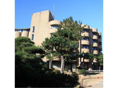 a large building with a tree in front of it at Hotel Tetra Resort Shizuoka Yaizu - Vacation STAY 35247v in Yaizu