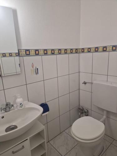 a bathroom with a white toilet and a sink at Schatzberg in Überlingen