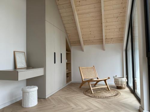 a room with a chair and a wooden ceiling at Dolina Ciszy - Wypoczynek i relaks pod sosnami in Łubiana