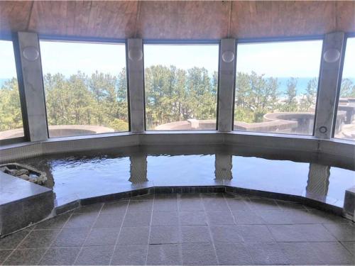 - une piscine d'eau dans un bâtiment avec fenêtres dans l'établissement Hotel Tetra Resort Shizuoka Yaizu - Vacation STAY 35233v, à Yaizu