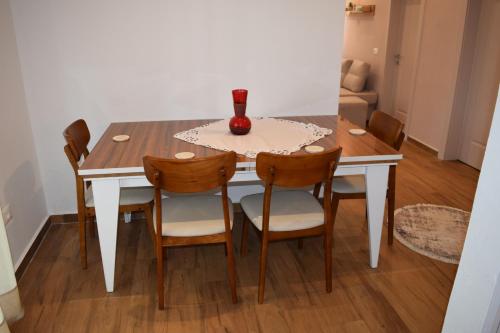 a dining room table with chairs and a vase on it at Chronos Villa Golem, Durrës in Durrës
