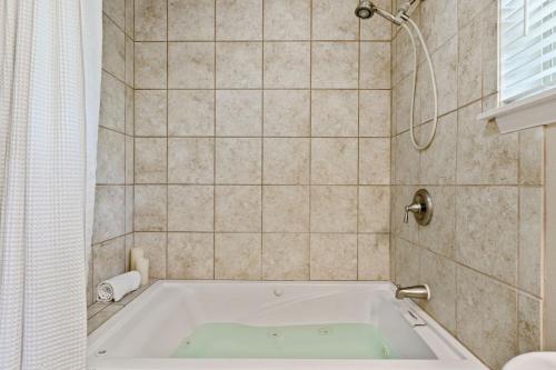 a bath tub in a bathroom with a shower at Blanco Riverside Cottages in Blanco