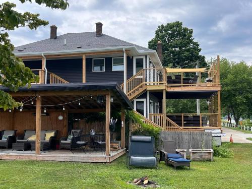 a large house with a porch and a deck at RiverSuite1 - A mesmerizing river and bridge view. in Russell