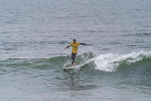 a man riding a wave on a surfboard in the ocean at Graffi Beach House in Florianópolis