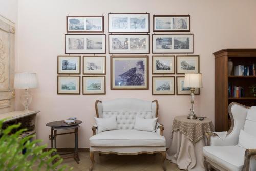a living room with a white chair and pictures on the wall at Hotel Il Nido in Amalfi