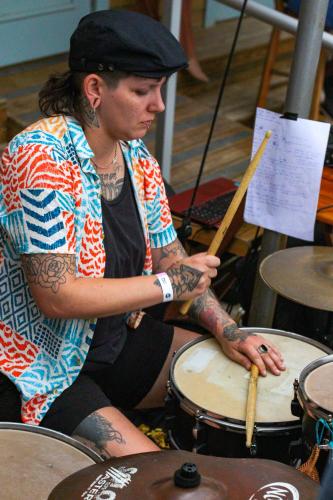a woman playing drums with a wooden instrument at Graffi Beach House in Florianópolis