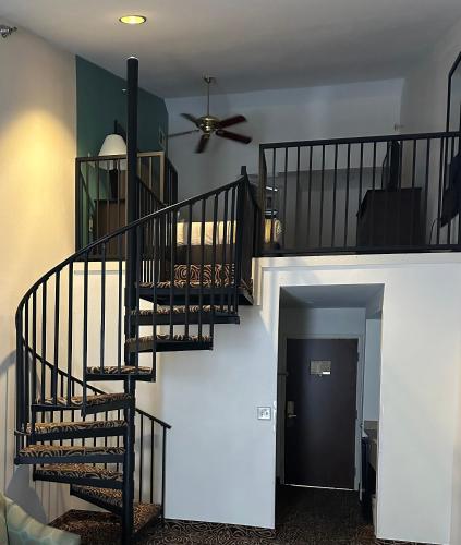 a spiral staircase in a living room with a ceiling fan at Country Inn & Suites by Radisson, Murrells Inlet, SC in Myrtle Beach