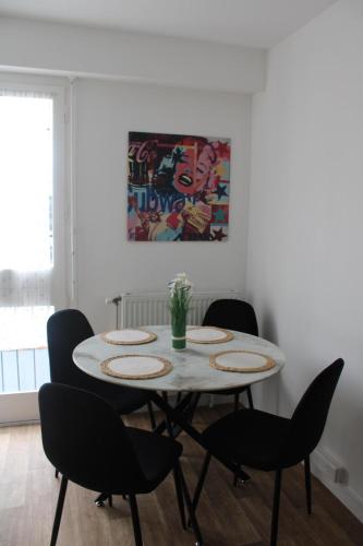 une salle à manger blanche avec une table et des chaises blanches dans l'établissement Studio, à Livry-Gargan