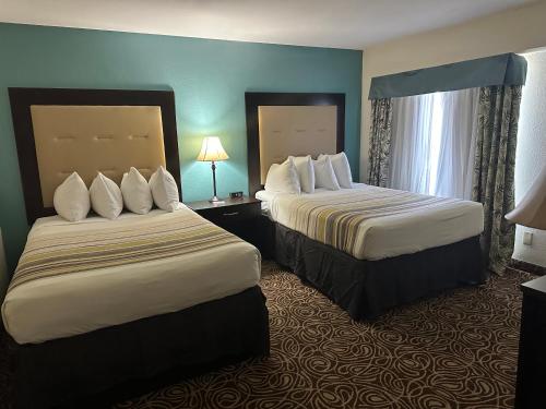 a hotel room with two beds and a window at Country Inn & Suites by Radisson, Murrells Inlet, SC in Myrtle Beach