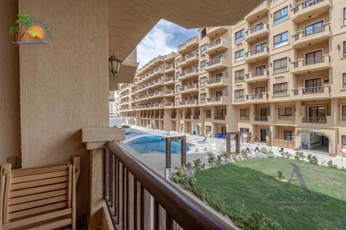 een balkon van een groot appartementencomplex met een tuin bij Turtles Beach Resort Hurghada By VTGooo in Hurghada