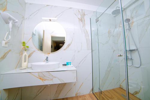 a bathroom with a sink and a mirror at Hotel Ilion in Paralia Katerinis