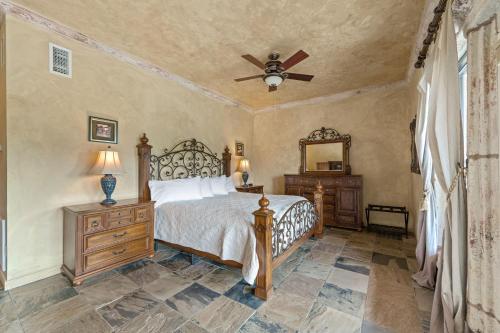 a bedroom with a bed and a ceiling fan at Blanco Riverside Cottages in Blanco