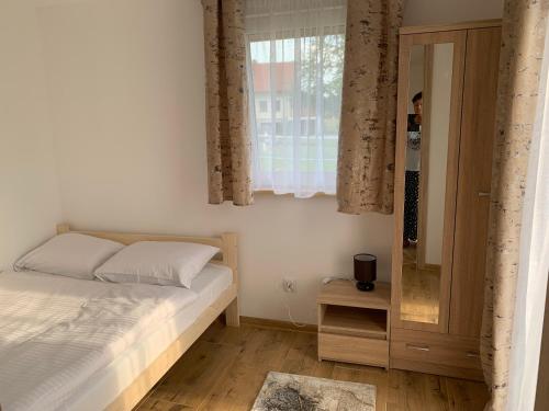 a bedroom with a bed and a window and a mirror at ZIELONA DOLINA - kompleks dla rodzin z dziećmi in Mikołajki