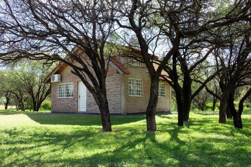 a brick house with trees in front of it at Cabañas El Duende in Quines