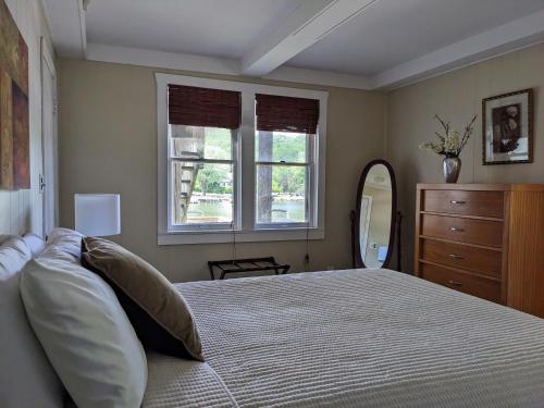 a bedroom with a bed and a dresser and windows at Casual Living Extended Stay Hotels in Algonquin