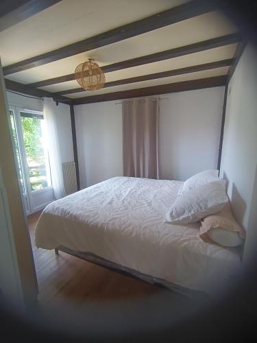 - une chambre avec un lit blanc et du parquet dans l'établissement Maison avec Piscine privée sans vis à vis 6 personnes, à Chevillon