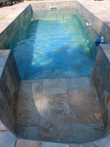 - une piscine avec un sol en pierre et de l'eau bleue dans l'établissement Maison avec Piscine privée sans vis à vis 6 personnes, à Chevillon