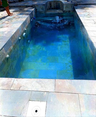 une piscine d'eau bleue avec une personne debout dedans dans l'établissement Maison avec Piscine privée sans vis à vis 6 personnes, à Chevillon