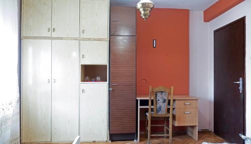 ソコバニャにあるApartmani Aleksić - AS u centru Sokobanjeのデスクと木製キャビネット付きの客室です。