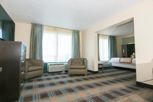 a hotel room with a bed and a living room at Wingate By Wyndham - Orlando International Airport- Free Hot Breakfast in Orlando