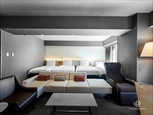 a hotel room with two beds and a couch at Daiwa Roynet Hotel Nishi-Shinjuku PREMIER in Tokyo