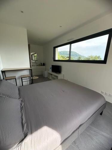 a bedroom with a large bed with a large window at chambre au calme in Saint-Jean-dʼArvey