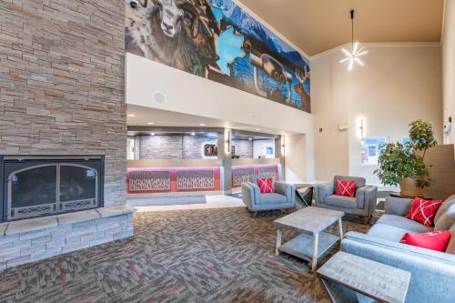 a lobby with a fireplace and couches at The Kanata by BCMInns - Hinton in Hinton