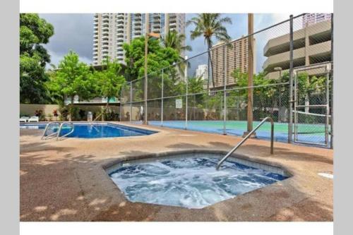 a hot tub in the middle of a swimming pool at Waikiki Studio Steps to Beach-Mall Free Parking-WiFi in Honolulu