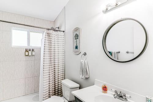 a white bathroom with a sink and a mirror at Ocean Oasis I in Key Colony Beach