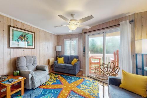 a living room with two chairs and a ceiling fan at A Place At The Beach 122 in Atlantic Beach