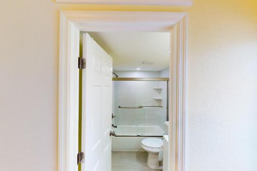 a white bathroom with a toilet and a shower at Palm Breeze Retreat 320 & 330 in Key Colony Beach