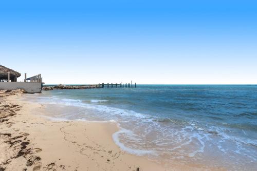 a sandy beach with a pier in the ocean at Palm Breeze Retreat 320 & 330 in Key Colony Beach