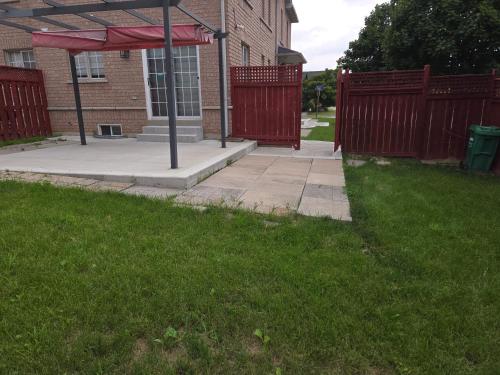 a sidewalk in front of a building with a red fence at Luxury Home in Mississauga in Mississauga