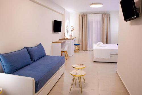 a living room with a blue couch and a bedroom at Hotel Ilion in Paralia Katerinis