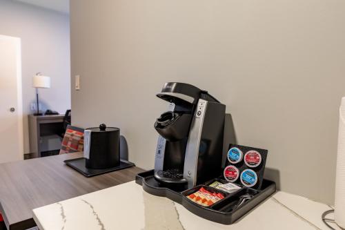 a coffee maker sitting on top of a table at The Kanata by BCMInns - Hinton in Hinton