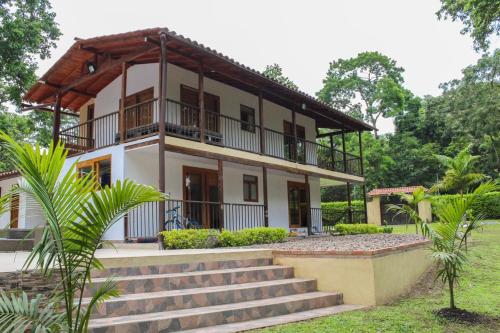 a house with stairs leading up to it at Hermosa CasaQuinta Con Piscina Privada. in Villeta