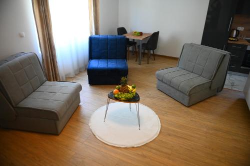 a living room with couches and a table with a bowl of fruit at Vila Mir in Banja Vrućica